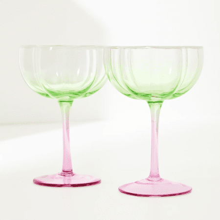 Two green and pink wine glasses on a white background